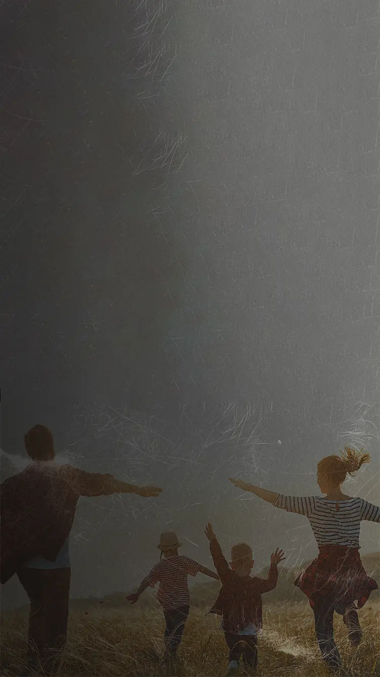 Mom, dad and two kids running in a field